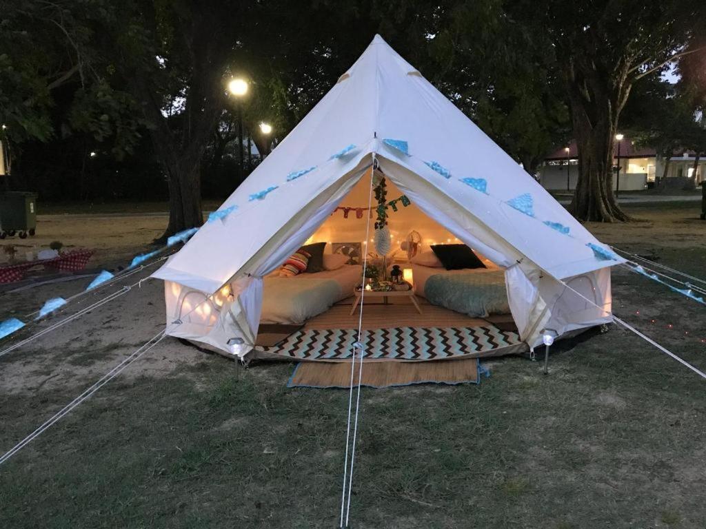 een witte tent in een veld 's nachts bij Glamping kaki singapore-Standard medium bell tent in Singapore