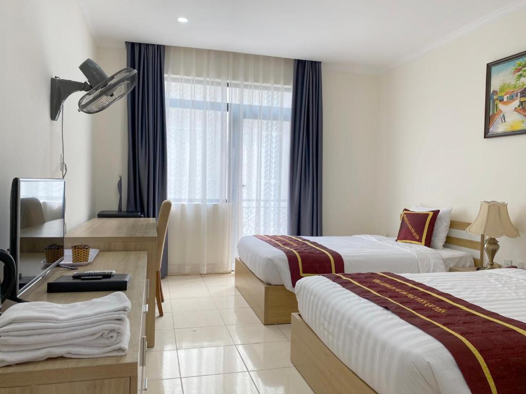 Postel nebo postele na pokoji v ubytování Nguyễn Quyền Hotel