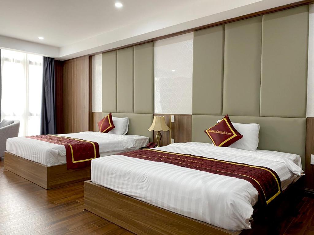 a hotel room with two beds and a window at Nguyễn Quyền Hotel in Hanoi