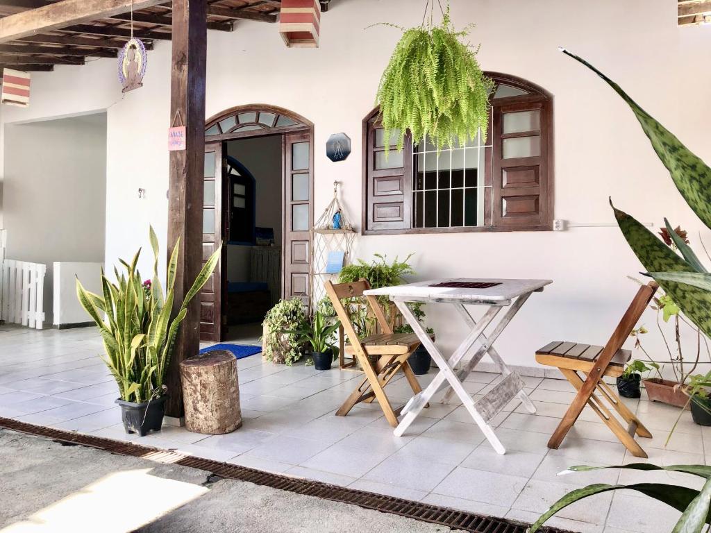 un patio con mesa, sillas y plantas en Odoyá Casa Hostel, en Arraial d'Ajuda