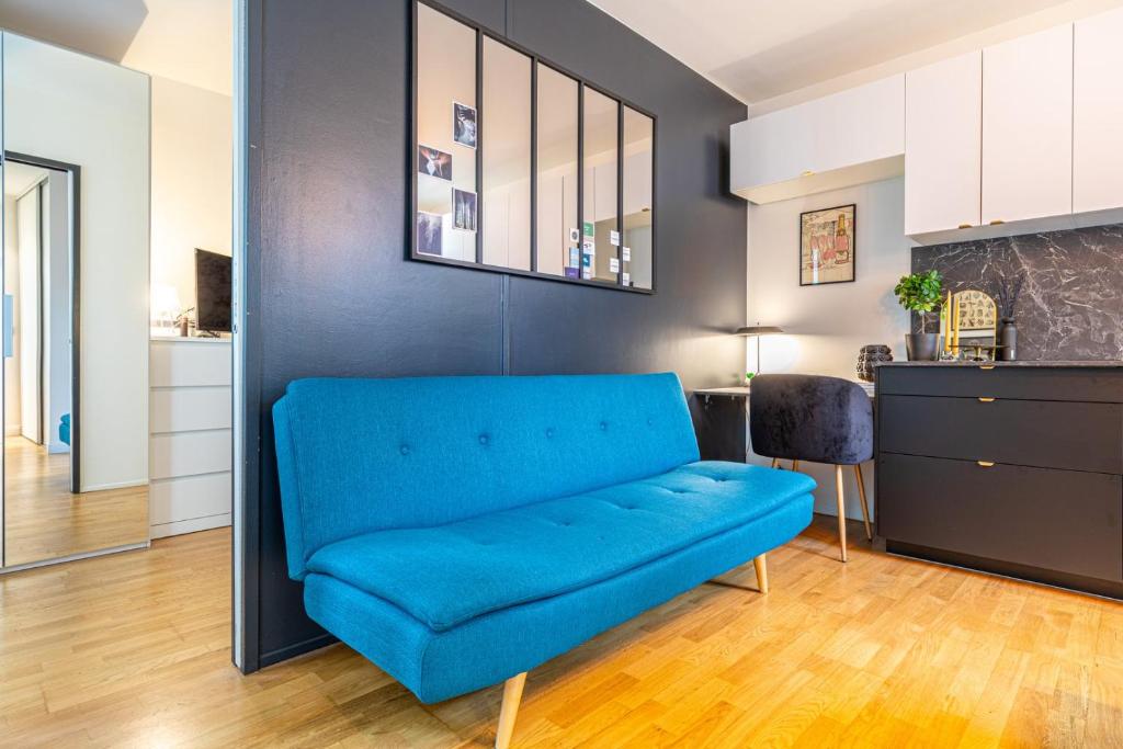 ein blaues Sofa im Wohnzimmer mit Küche in der Unterkunft GuestReady - Blue Nest near Le Parc des Princes in Boulogne-Billancourt