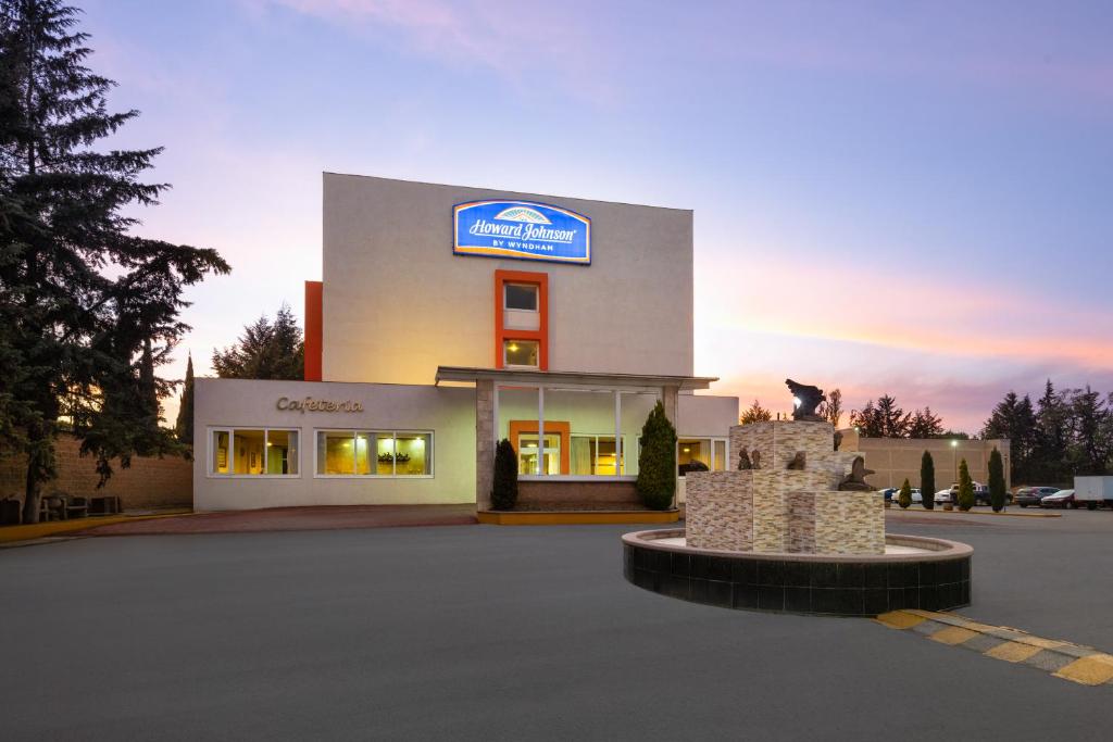 a building with a sign on the side of it at Howard Johnson by Wyndham Toluca in Toluca