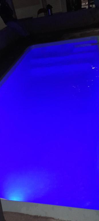 uma piscina azul de água num quarto em Chácara jerivá em Boituva