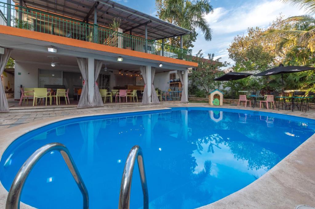 uma piscina em frente a um hotel com mesas e cadeiras em Jardín Mérida em Mérida