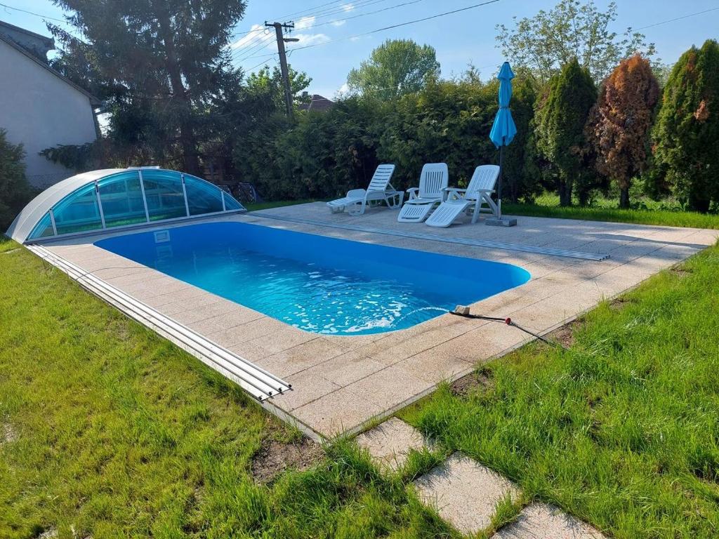 a swimming pool with two chairs and a tent at schönes Ferienhaus mit grossem Pool 4 km zum Balaton in Balatonszentgyörgy