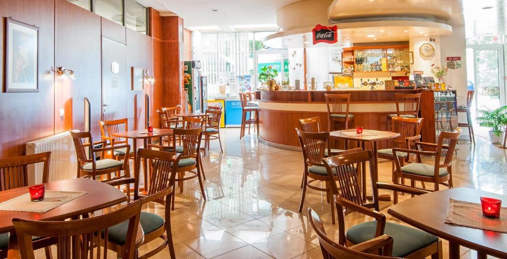 restauracja ze stołami i krzesłami oraz bar w obiekcie Apartman Hotel w mieście Bük