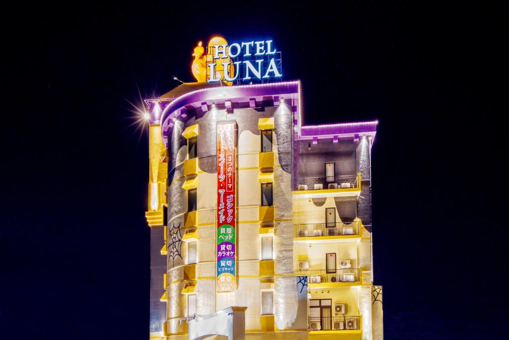 a building with a neon sign on top of it at HOTEL Luna Kawagoe Adult Only in Kawagoe