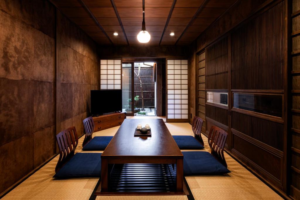 ein Esszimmer mit einem Tisch und Stühlen in der Unterkunft Rinn Shijo Machiya in Kyoto