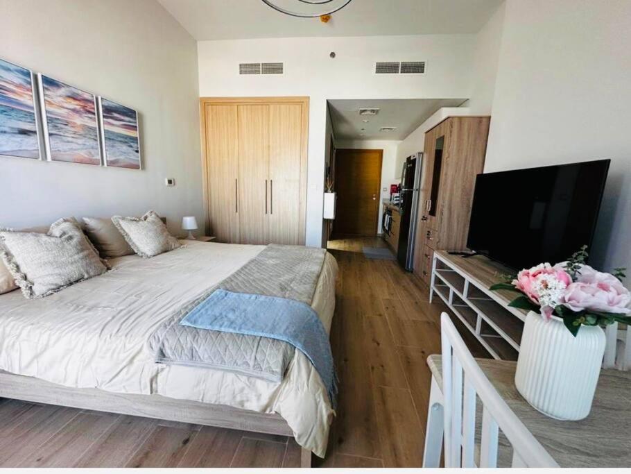 een slaapkamer met een groot bed en een flatscreen-tv bij Azizi Aura 1013 in Dubai
