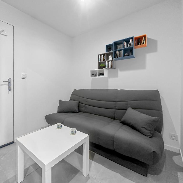 un salon avec un canapé et une table dans l'établissement Le Petit Torcieu, à Torcieu