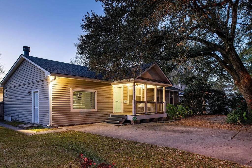 een klein huis met een veranda en een boom bij Veteran Owned Retreat with Games in Baton Rouge