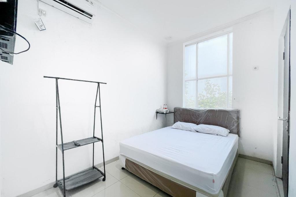 Ένα ή περισσότερα κρεβάτια σε δωμάτιο στο Citara Jaya Guesthouse Mitra RedDoorz