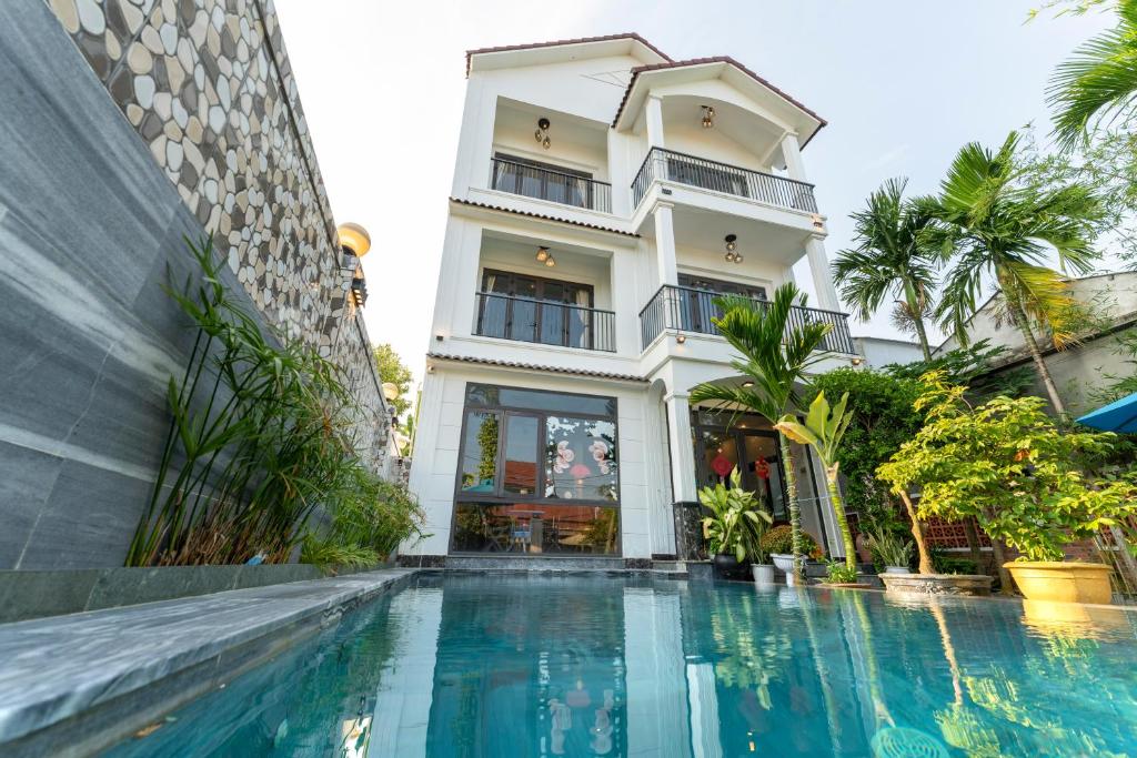 uma casa com piscina em frente a um edifício em Rice River Villa - Hoi An em Hoi An