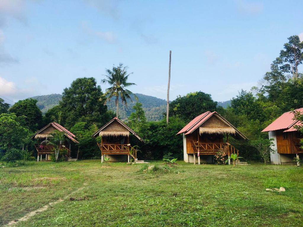 un grupo de cabañas con palmeras en un campo en Seree Bungalows, en Ko Chang