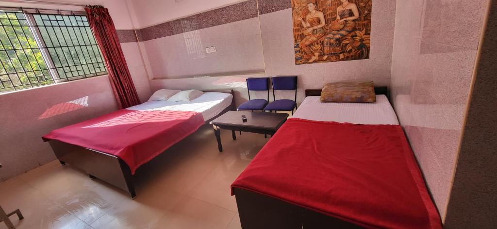 a room with two beds and a window at RMS cottage in Yercaud