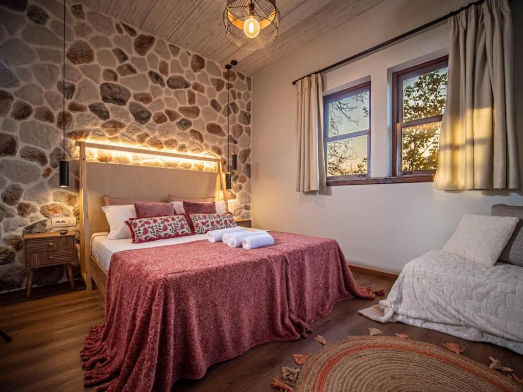 a bedroom with a bed and a stone wall at Αρχοντικό Πορταριάς in Portariá