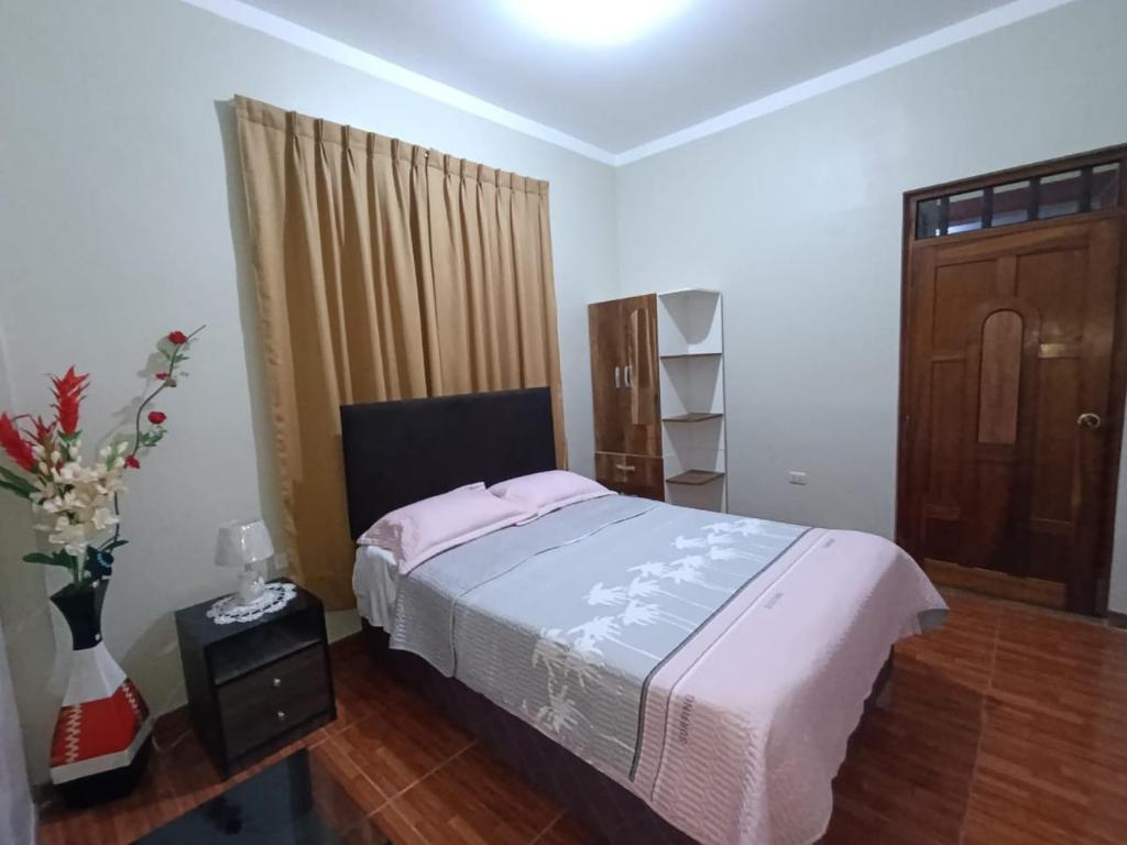 1 dormitorio con 1 cama y suelo de madera en AlojaRous2, en Tingo María