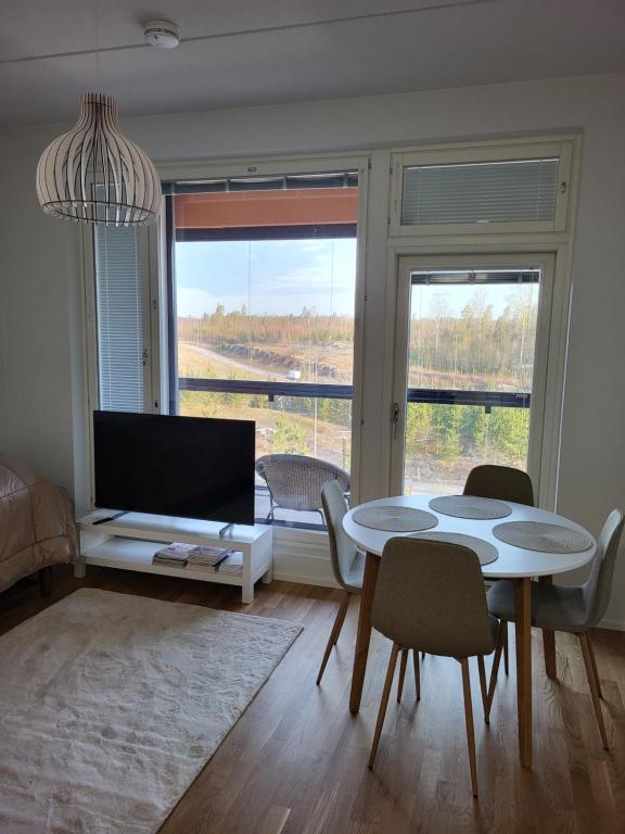 Yksiö Sarvvikissa في كيركونومي: غرفة معيشة مع طاولة وكراسي وأريكة