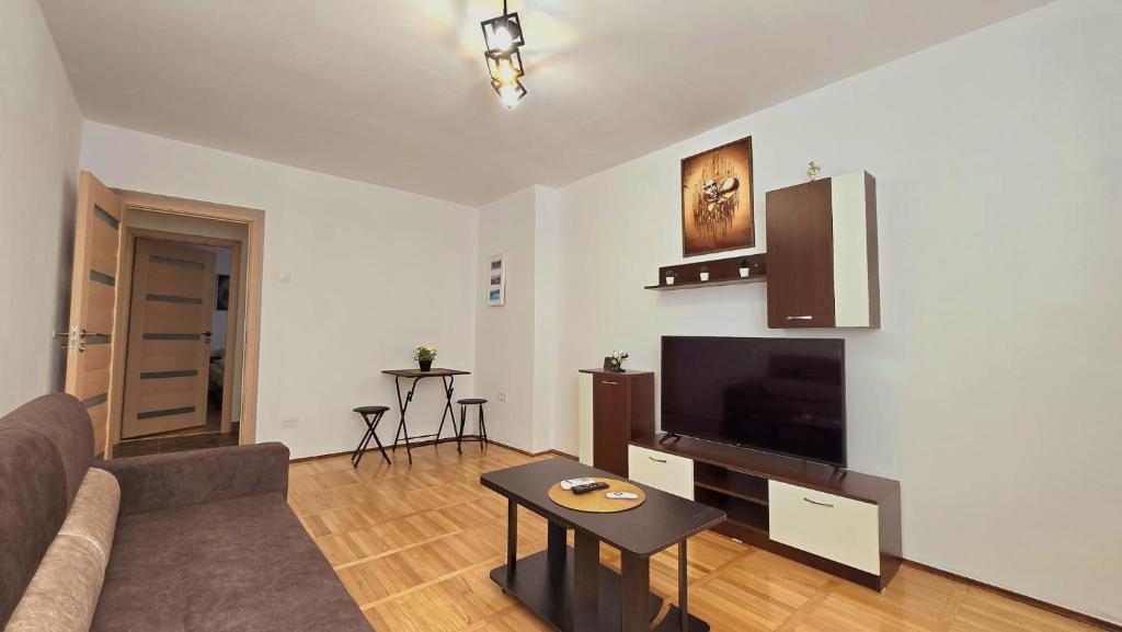 a living room with a couch and a flat screen tv at Apartament Confort Hd in Hunedoara