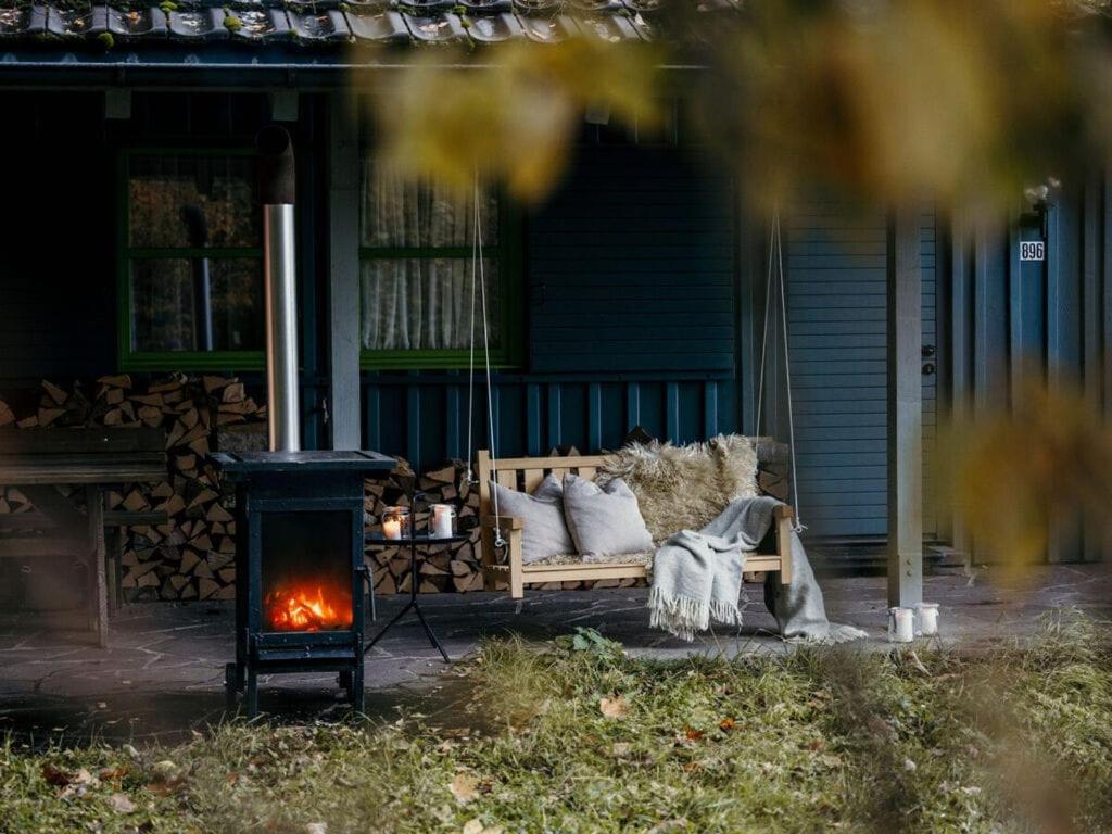 a couch sitting on a porch next to a stove at Bregenzerwald holiday home in Egg