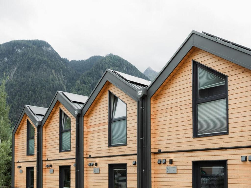 a row of houses with mountains in the background at HÜSLE by UNIQUE PLACES in Bludenz