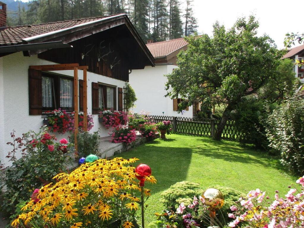 einen Garten vor einem Haus mit Blumen in der Unterkunft Holiday apartment Maurer Apartment Laber in Oberammergau