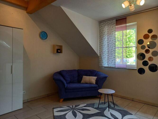 - un salon avec un canapé bleu et une fenêtre dans l'établissement Nice apartment in Mossautal, à Mossautal