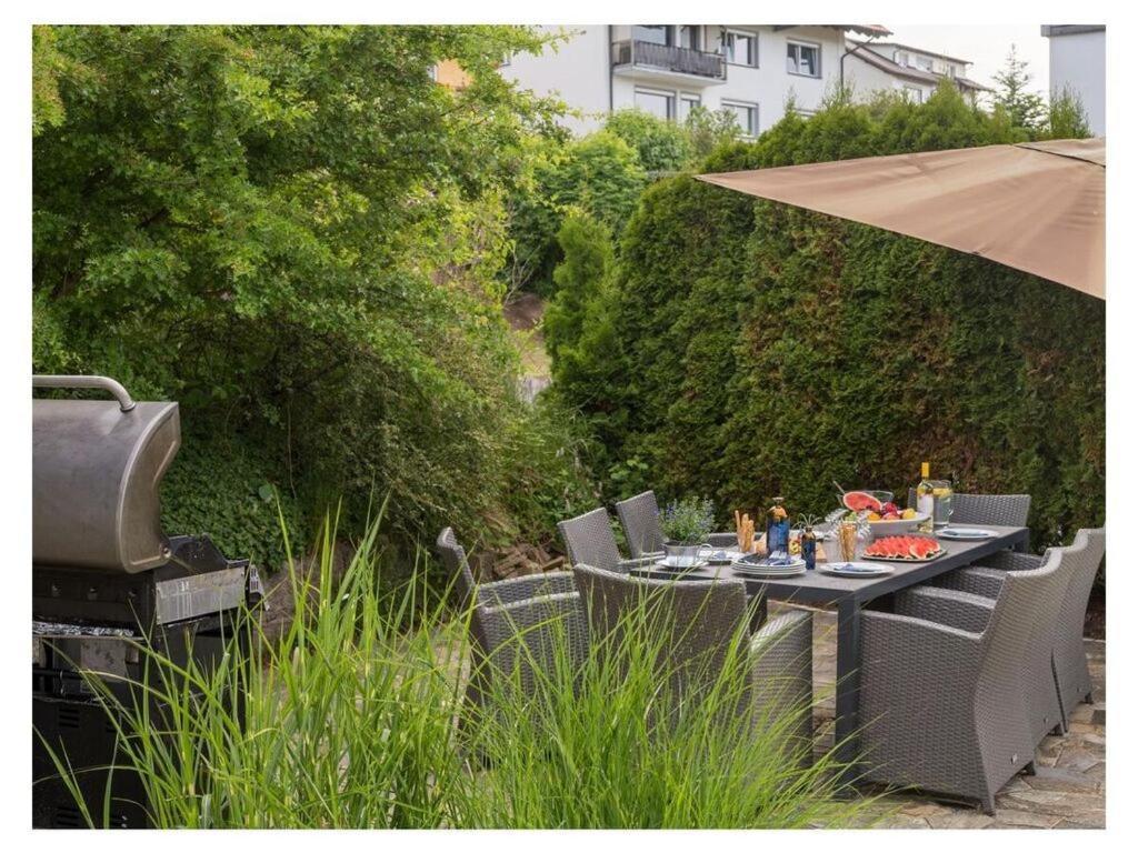 a table with chairs and an umbrella in a garden at Historical and modern in Schonach