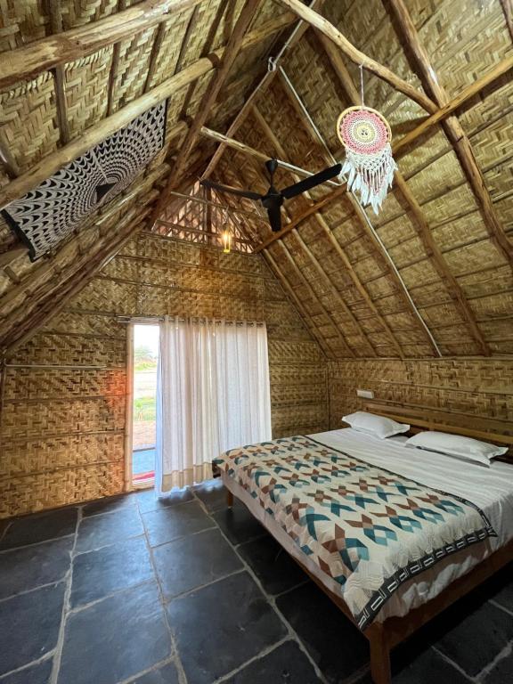 um quarto com uma cama num tecto de madeira em Tropical Hampi em Hampi