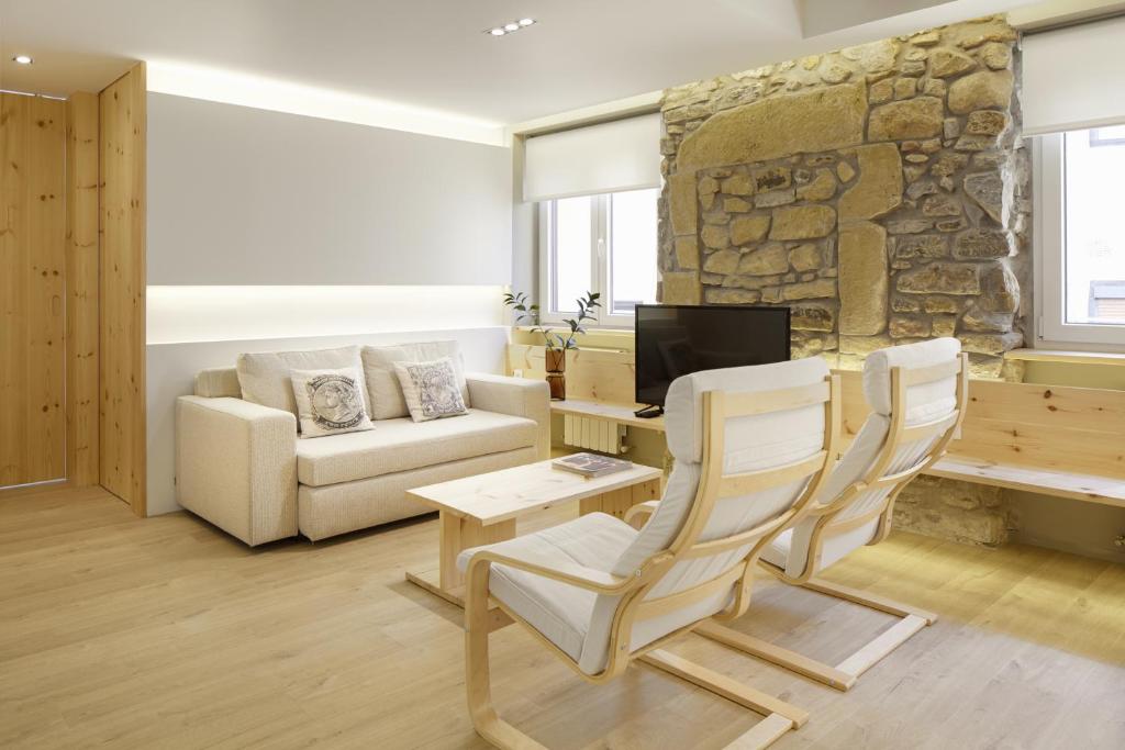 salon z kanapą i kamienną ścianą w obiekcie Santa Maria by FeelFree Rentals w mieście San Sebastián