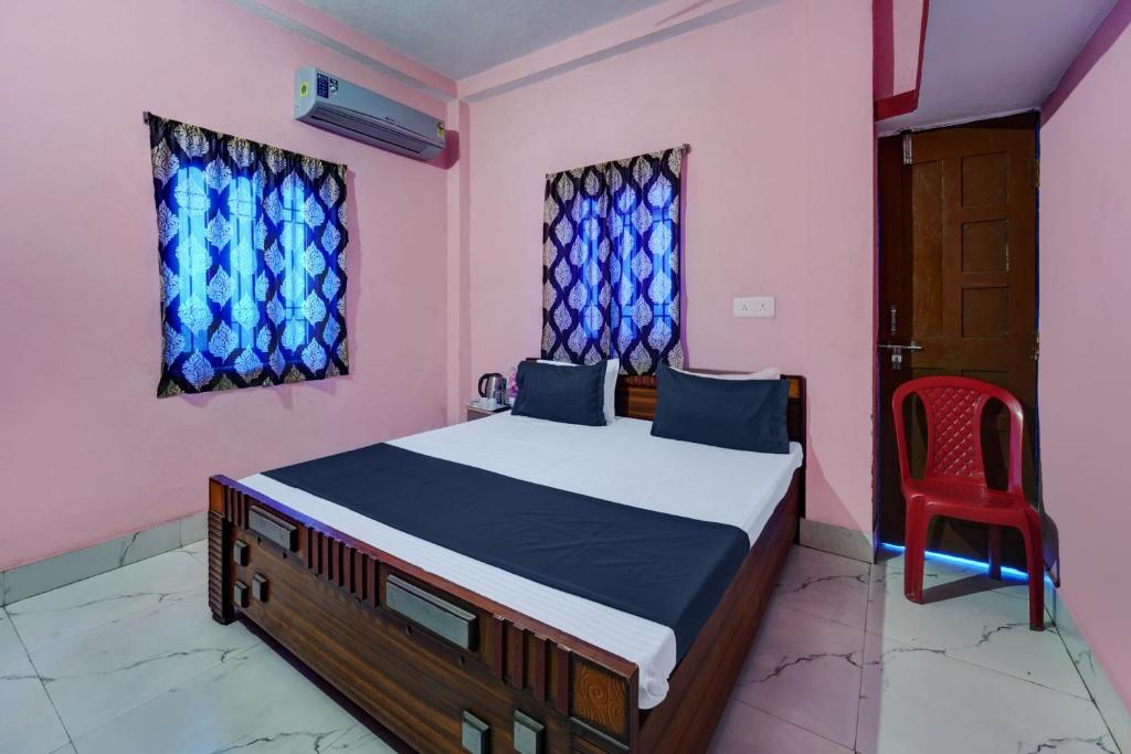 1 dormitorio con 1 cama y 1 silla roja en SPOT ON S Hotel & Restaurant en Patna