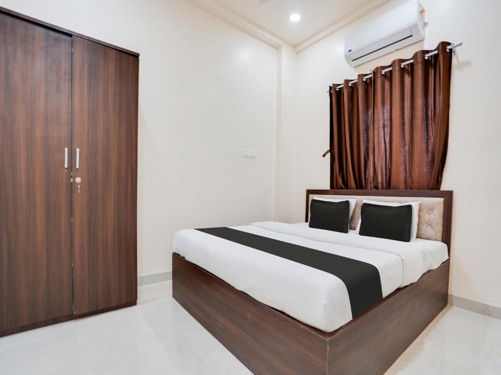 a bedroom with a large bed and a wooden cabinet at OYO UTS STAY IN in Nagpur