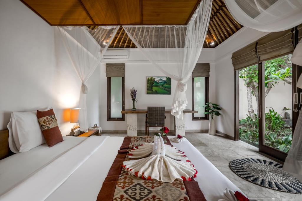 a bedroom with a bed with a dress on it at Sayang Garden & Pool Vllla Ubud in Ubud