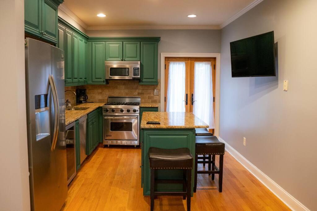 a kitchen with green cabinets and a table with chairs at *RARE* Entire Society Hill House in Philadelphia