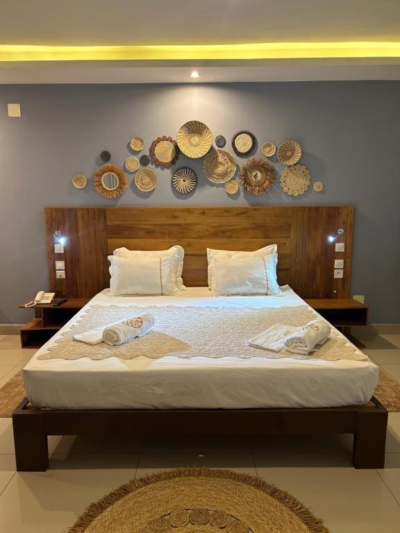 sypialnia z dużym łóżkiem z płytkami na ścianie w obiekcie ZARA HOTEL w Antananarywie