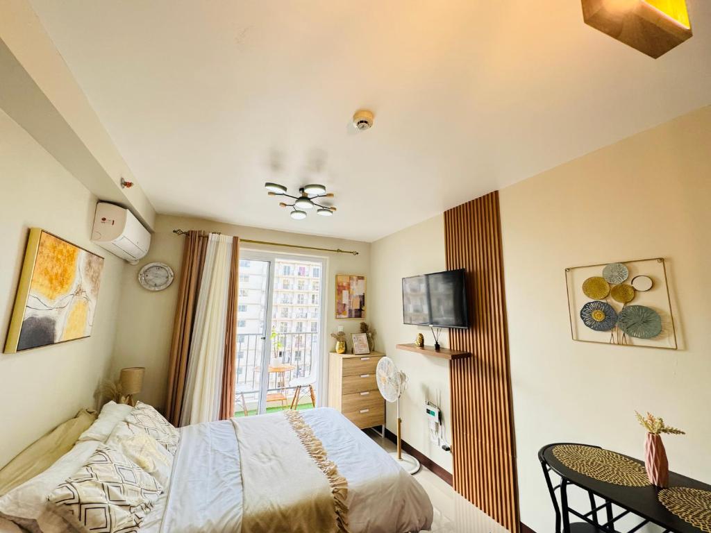 1 dormitorio con cama, mesa y TV en Clarity’s Staycation en Basbas