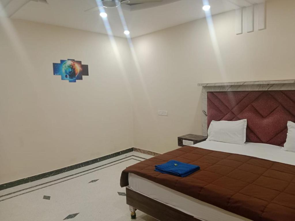 Schlafzimmer mit einem Bett und Wandbeleuchtung in der Unterkunft Hotel Rudra Palace in Khajurāho
