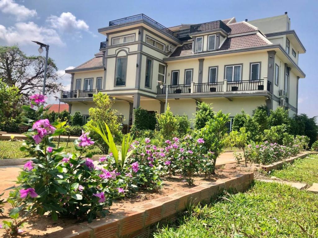 ein großes Haus mit Blumen im Vorgarten in der Unterkunft Aspire Homestay in Siem Reap