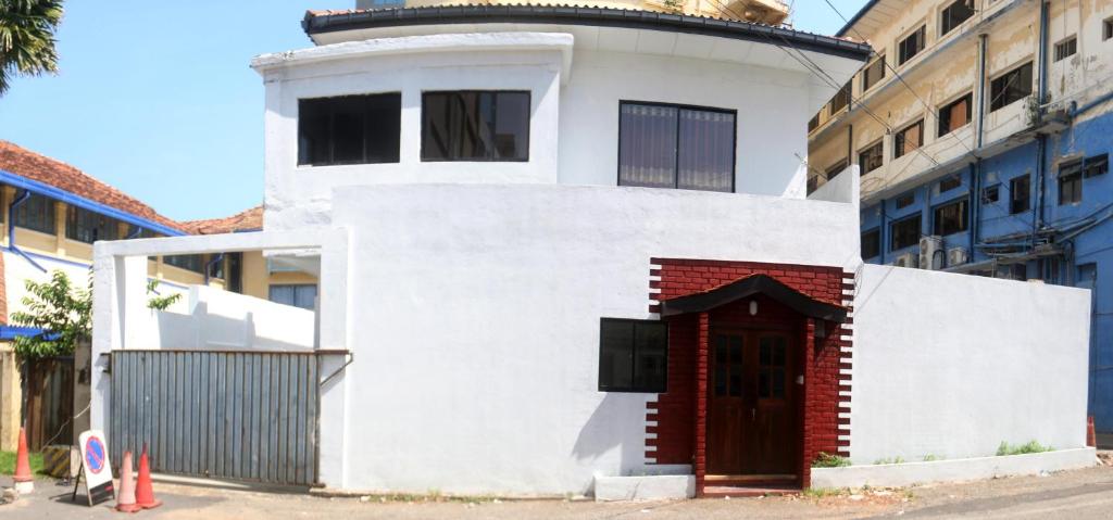 una casa bianca con una porta rossa di fronte a un edificio di Mountain View Holidays a Colombo