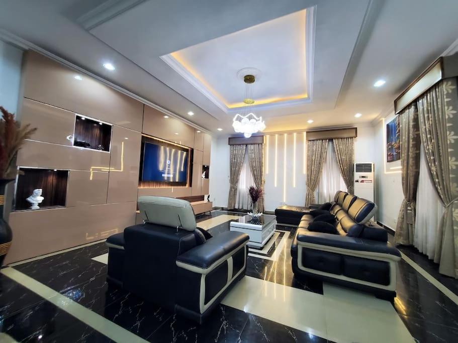 uma ampla sala de estar com um sofá e cadeiras em 3 bedrooms with Modern Amenities em Abeokuta