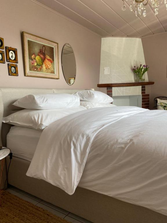 um quarto com uma cama com lençóis brancos e um espelho em Sete Fontes - Agarone Holiday Nest em Agarone