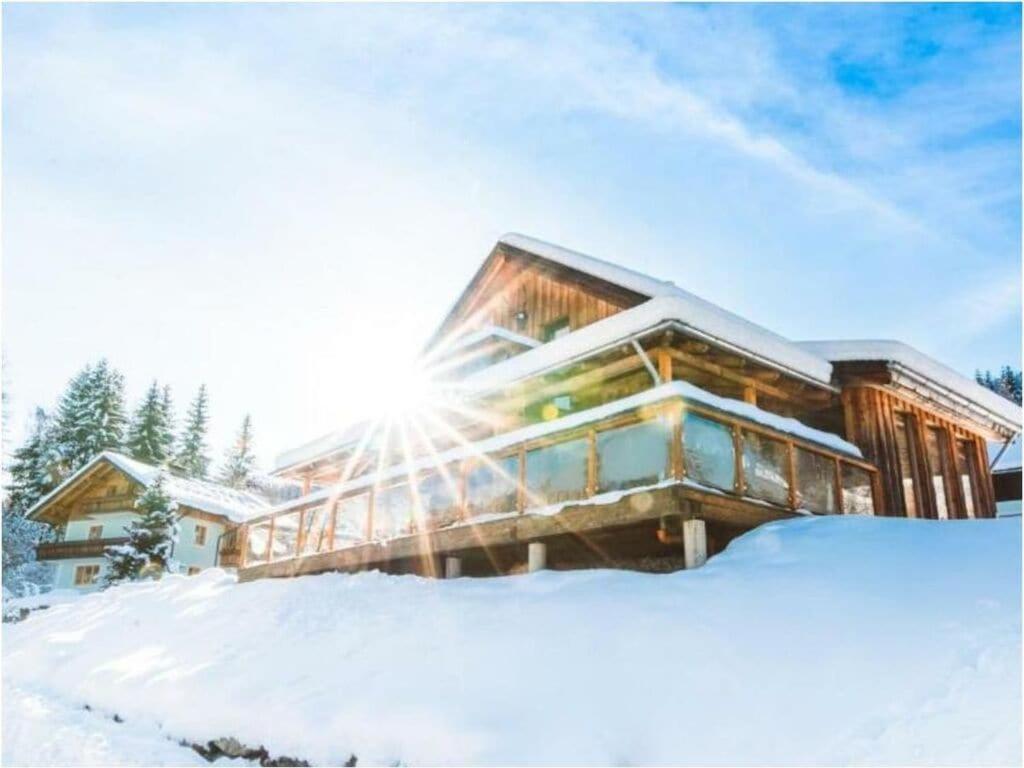 Ein Haus im Schnee mit Sonne in der Unterkunft Alpenglöckchen Modern retreat in Stadl an der Mur