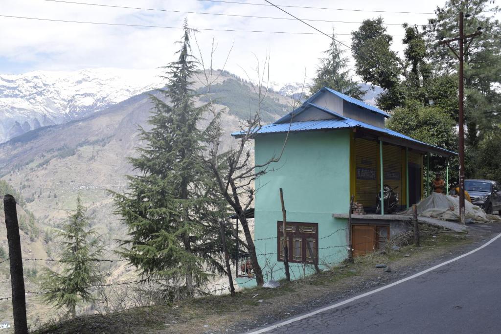 een klein blauw huis aan de kant van een weg bij NotOnMap- Hidden Hamlet Gowari in Tisa