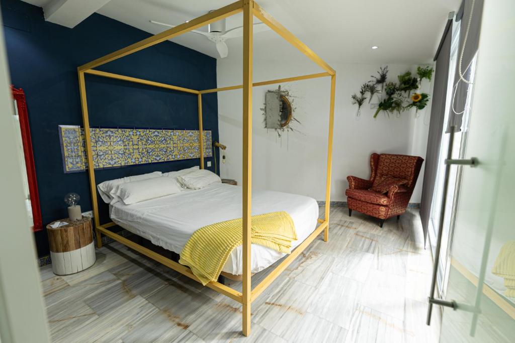 een slaapkamer met een hemelbed en een stoel bij Singular Home Sevilla Center Bikes free in Sevilla