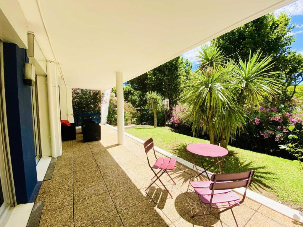 une terrasse avec 2 chaises et une table rose dans l'établissement Eagle - Trois pieces de standing quartier du golf MAE-4094, à La Grande Motte