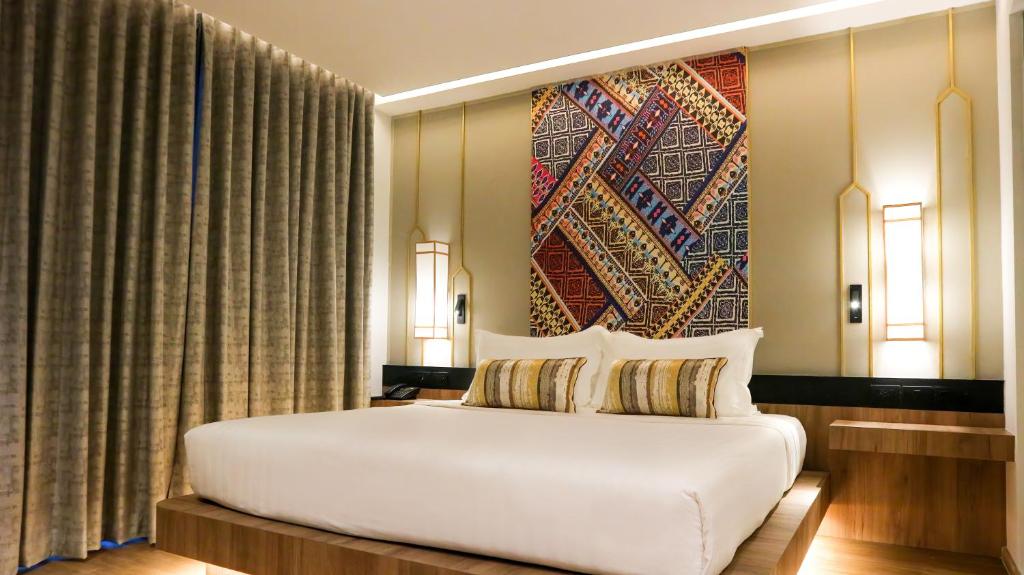清邁的住宿－Stay Collection Chiangmai，卧室配有白色的床和墙上的大画作