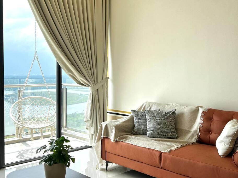 a living room with a couch and a large window at Bora Residences by Antlerzone in Johor Bahru