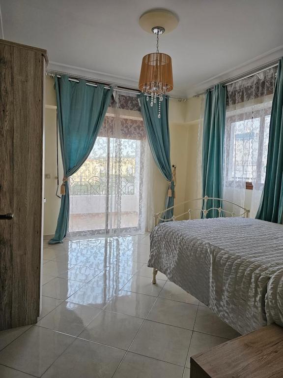 Schlafzimmer mit einem Bett mit blauen Vorhängen in der Unterkunft la perle du tanger R in Tangier