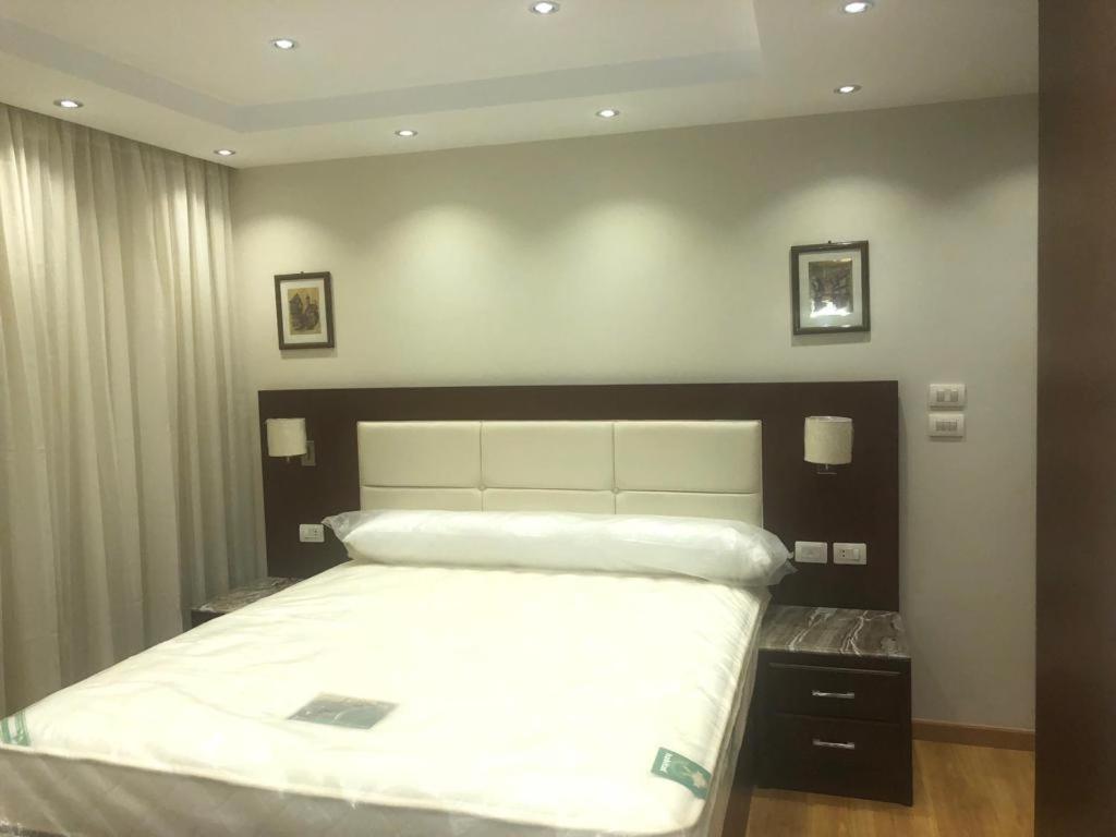 una camera da letto con un grande letto bianco di فيصل والهرم a Il Cairo