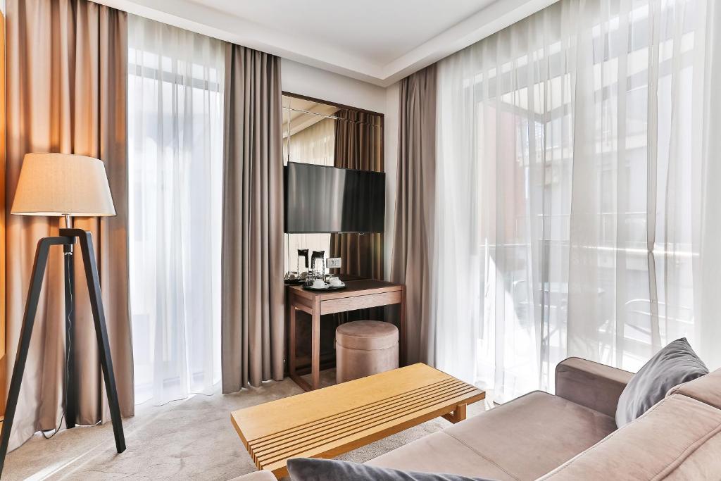 uma sala de estar com um sofá e uma mesa em Hotel Fagus by Aycon em Budva